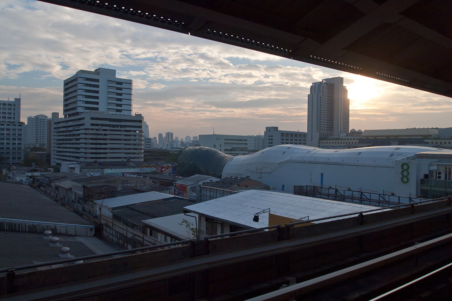 夕陽下從暹羅 BTS 車站拍攝的曼谷市景，呈現城市交通環境，並非曼谷柏悅或瑞吉酒店的實景。