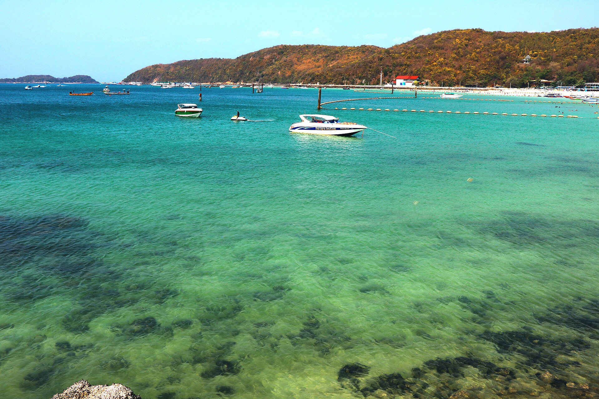 格蘭島塔威恩海灘的淺色海水與近岸船隻，呈現島上海岸環境，並非 Cape Haven 或 Ennkai 的旅館照片