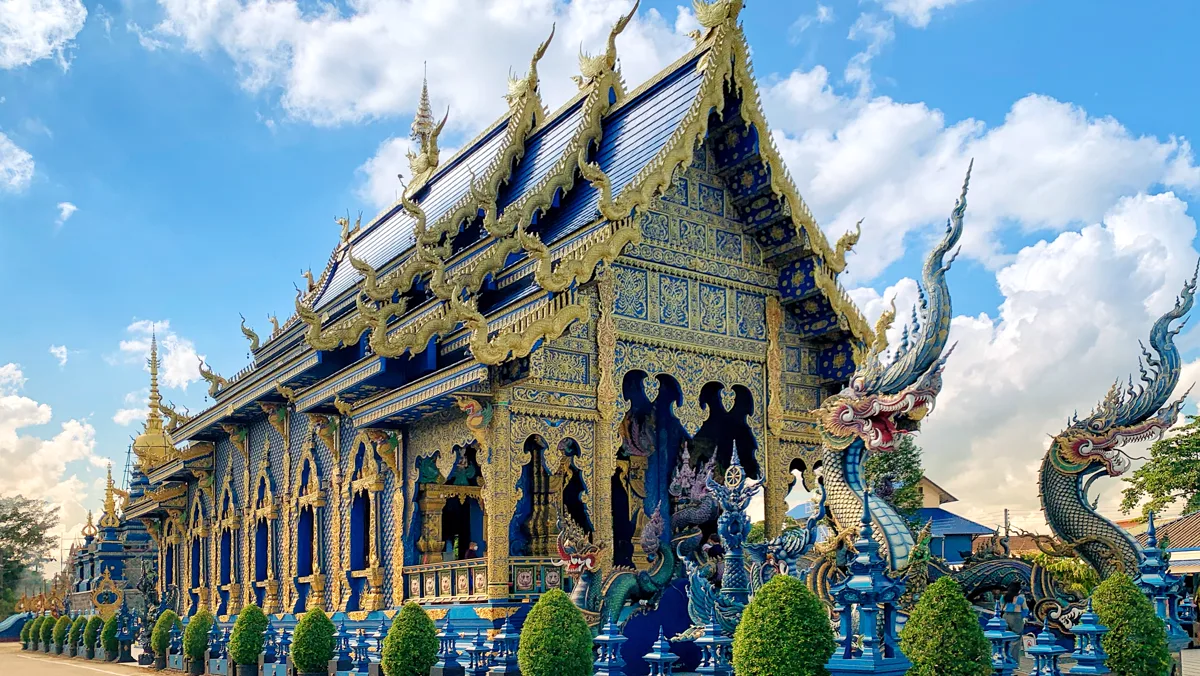 清萊藍廟 Wat Rong Suea Ten 的藍色外牆與白色裝飾，作為城市文化景點示意，並非兩間飯店實景