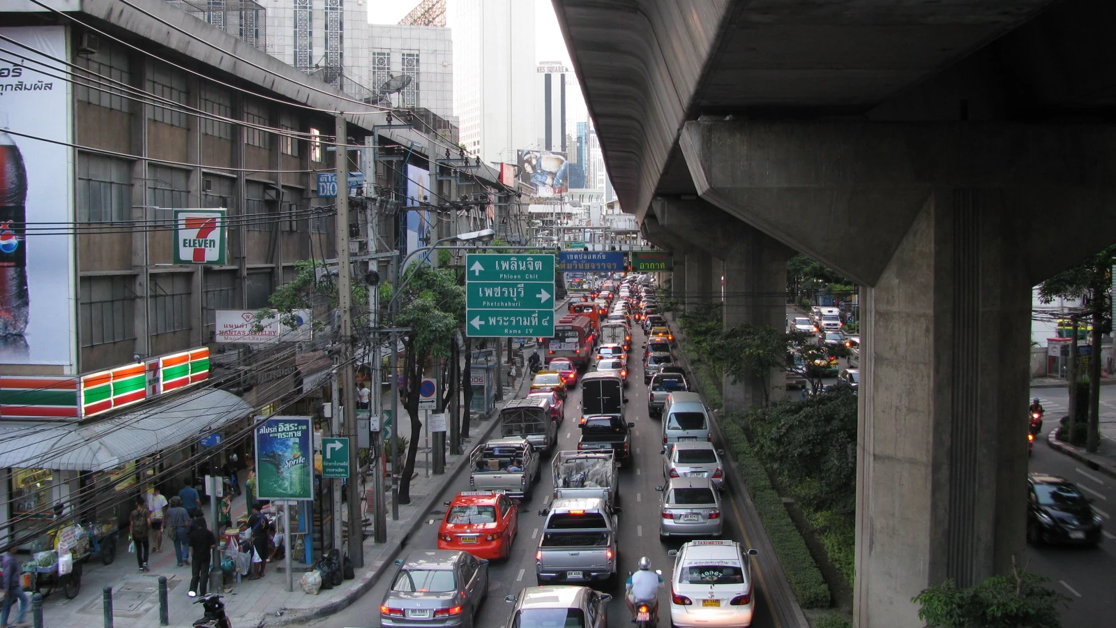 曼谷素坤逸路高架軌道下的街道車流；此為城市街景背景，並非阿里、通羅或伊卡邁的特定店家。