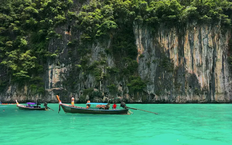 皮皮島萊島的長尾船停在石灰岩峭壁環繞的皮萊潟湖