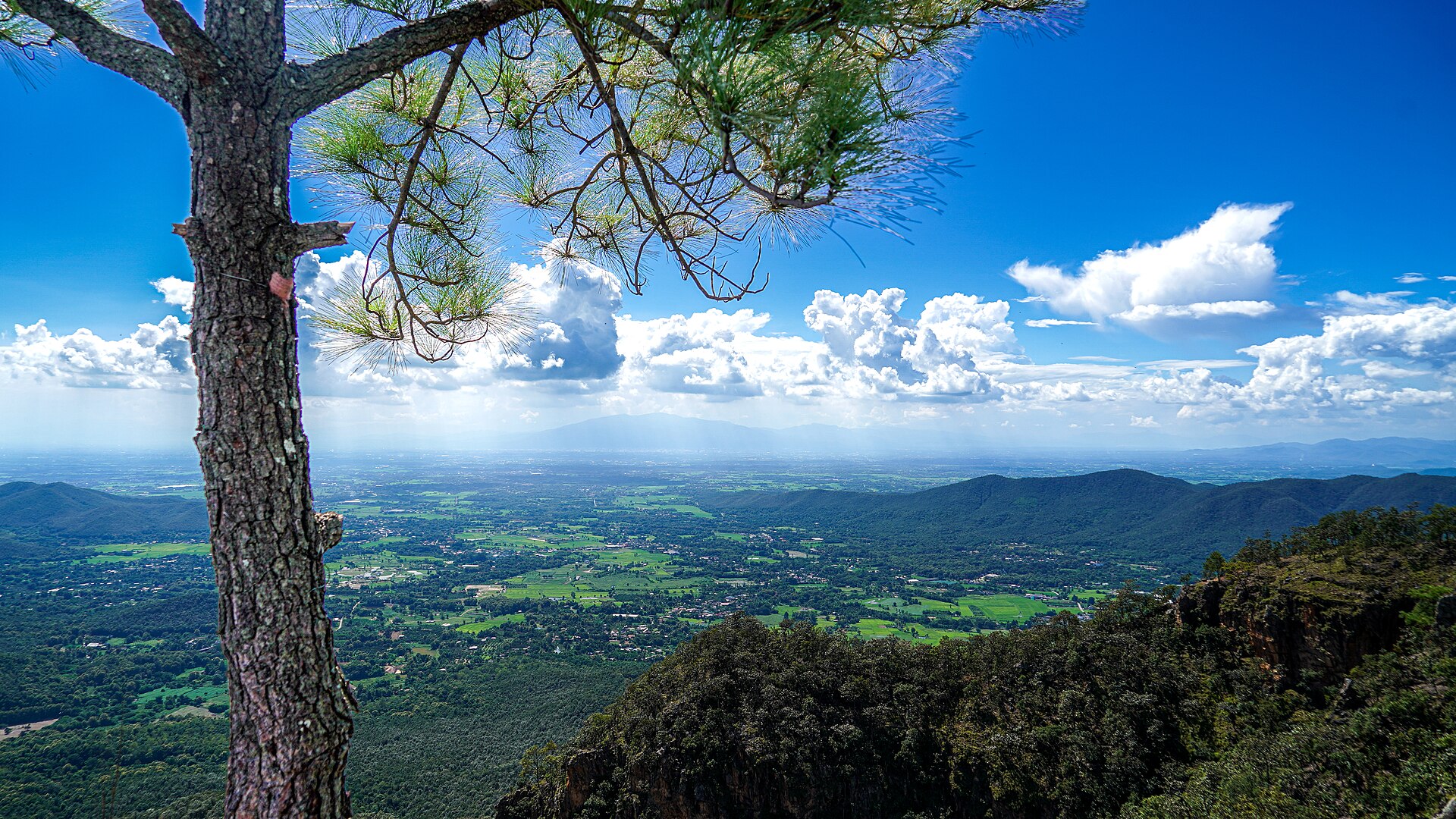 從清邁湄塔克萊國家公園的 Doi Nang Mo 觀景點眺望群山、山谷與低地，作為清邁山區住宿的地景背景；不是飯店或房內浴池照片。