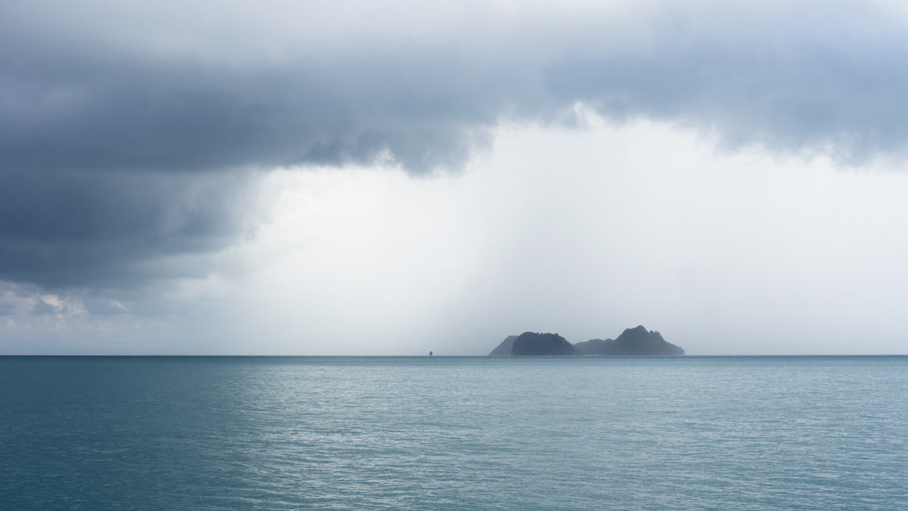 五月的泰國灣，遠處的小島上方聚集雨雲。