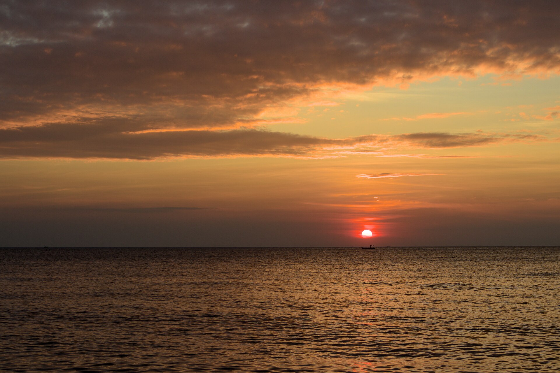 Na Jomtien 海岸日落時分，一艘小船停在海面上，作為芭達雅海岸環境示意，並非 MASON 飯店或別墅實景